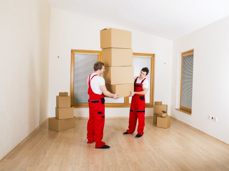 Professional movers carrying furniture during a local house move